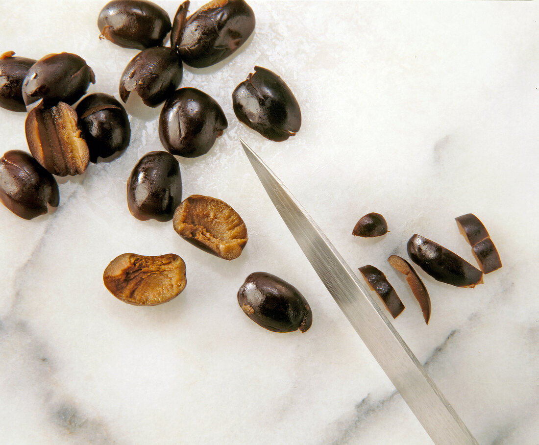 Close-up of black olives being sliced