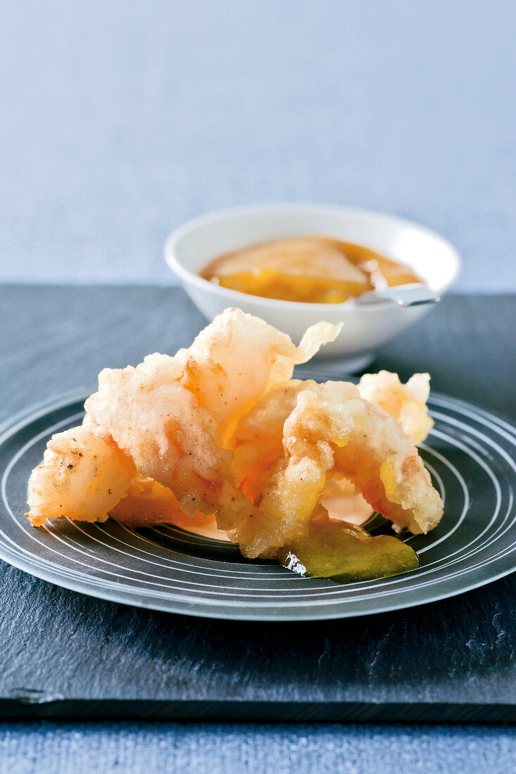 Close-up of tempura prawns with mango chutney on plate