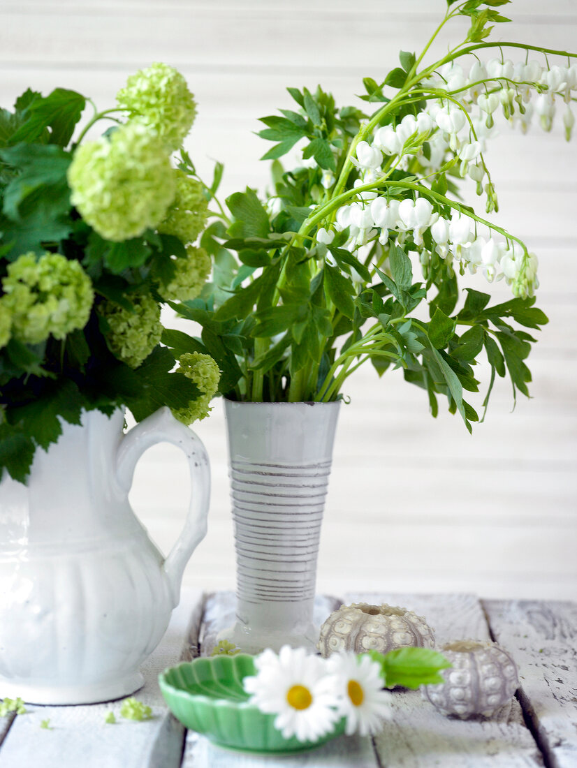 Close-up of white flowers in vases on wood