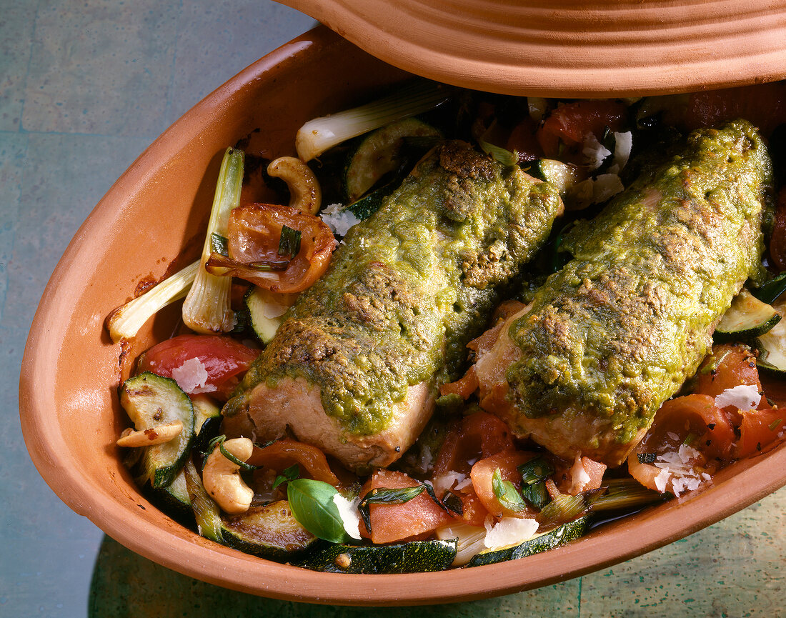 Pork fillet with herb crust, vegetables and nuts in roman pot