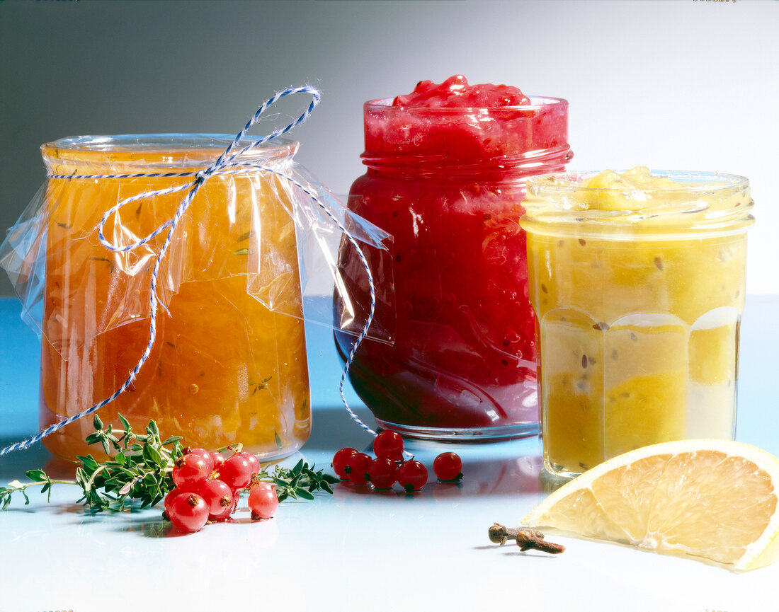 3 Sorten Marmelade in Gläsern, rot, gelb und orange
