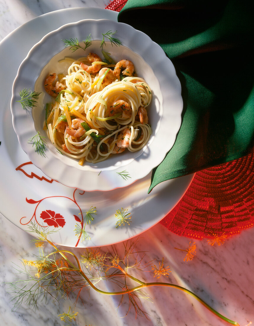 Spaghetti with shrimps and carrot strips in plate