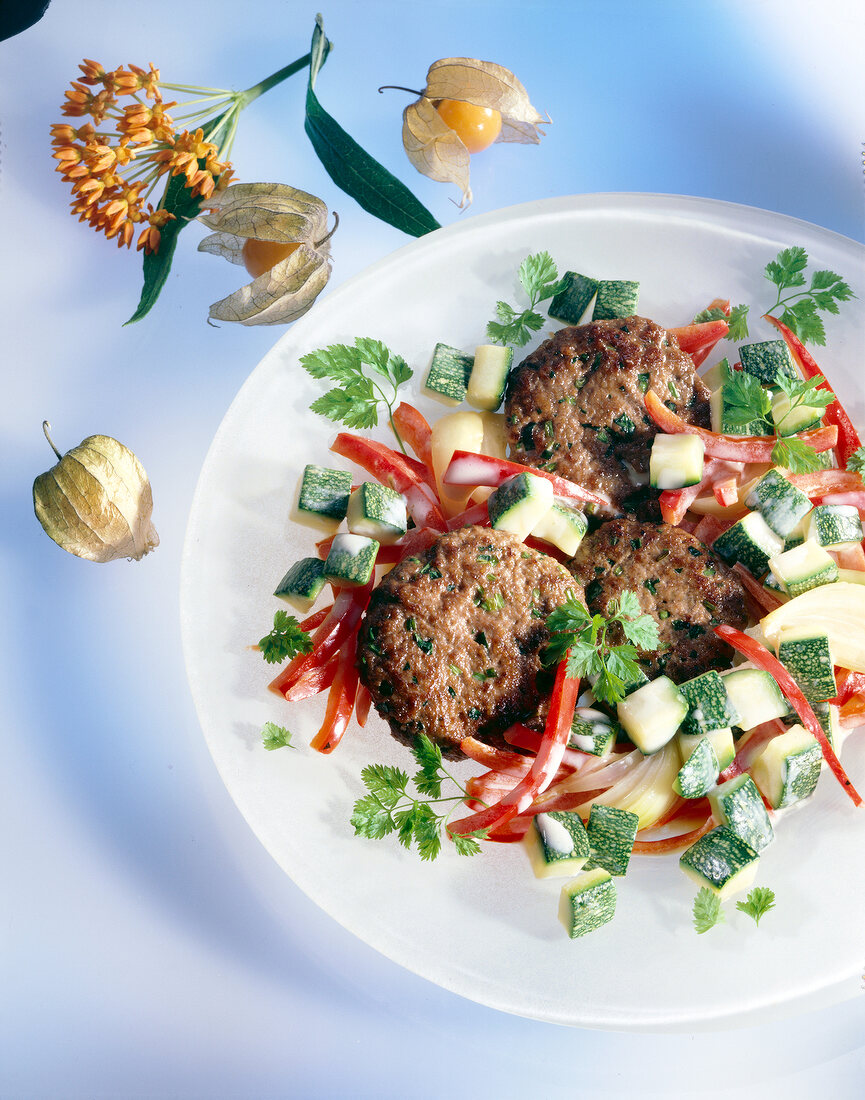 Frikadellen mit Paprika-Zucchini- Gemüse auf Teller