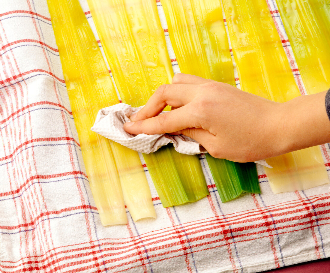 Patting dry cooked leeks with kitchen paper