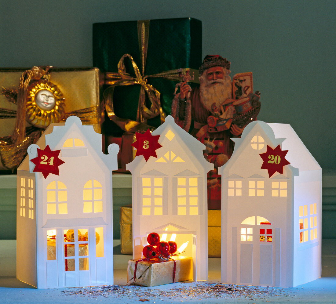 Illuminated house shaped advent calendar with numbers and Christmas decoration