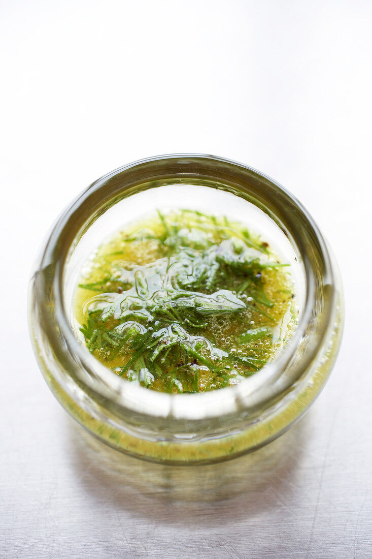 Sauce of honey with vegetable oil, mustard, chopped dill and ground pepper, close-up