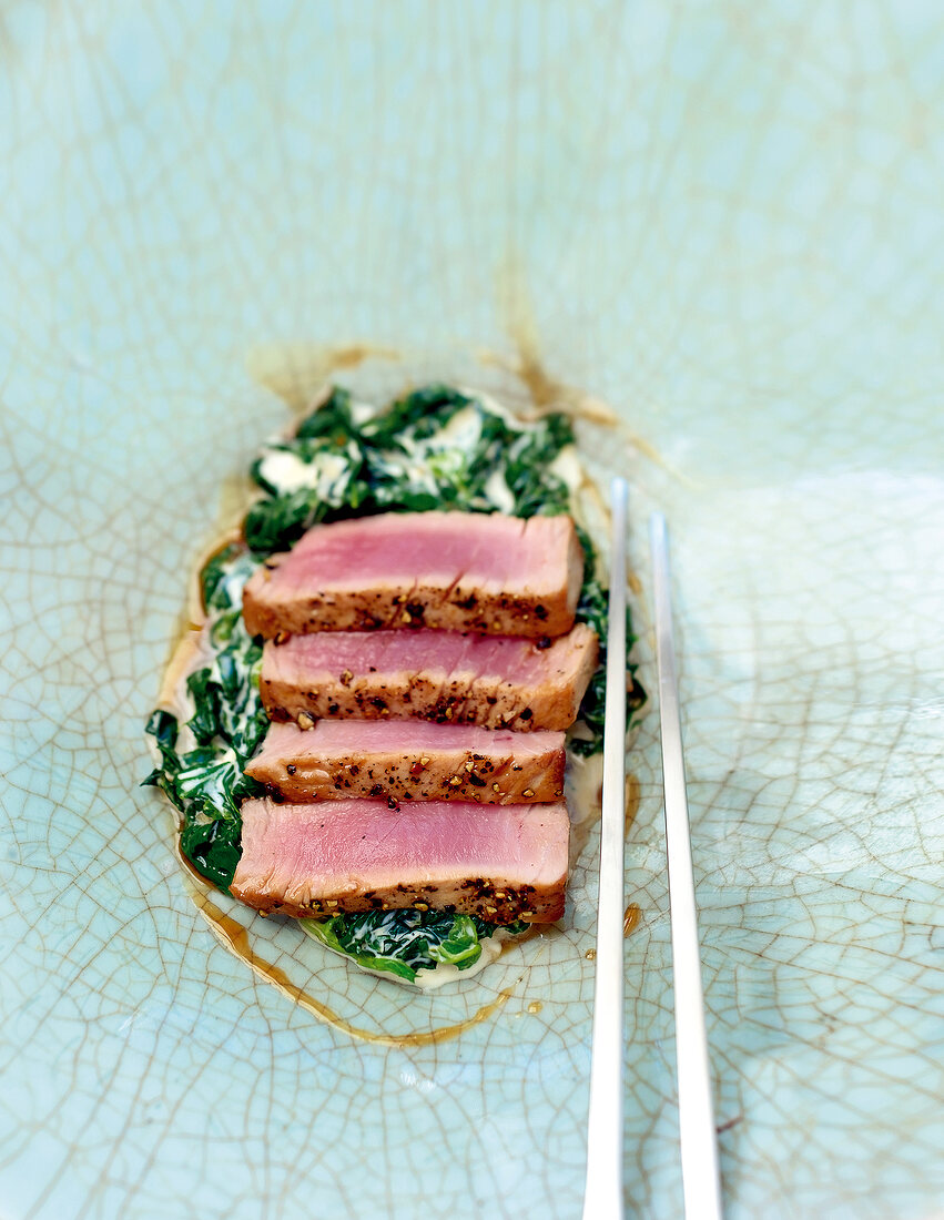 Close-up of rare tuna steak with creamy spinach