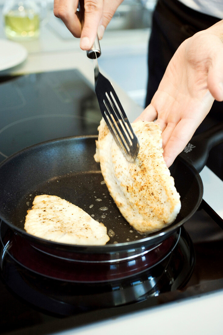 Roast turbot fillets being turned in a pan