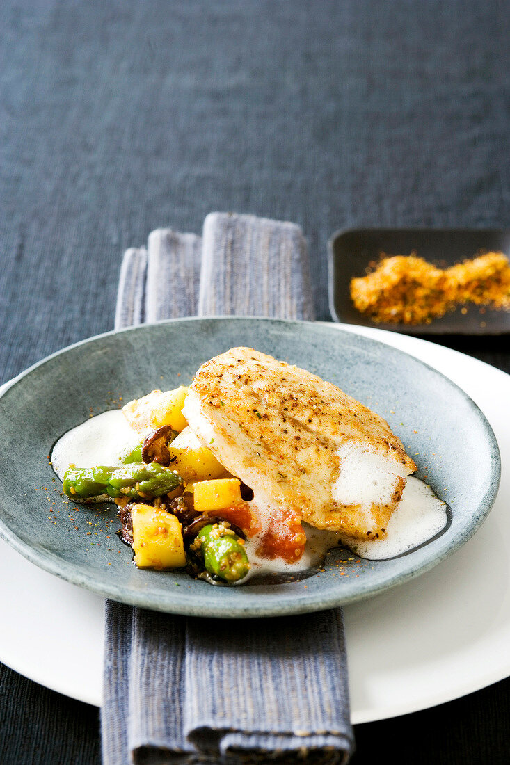 Roasted turbot fillet with spicy potato and vegetables in plate