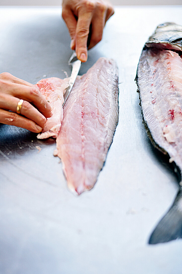 Removing flank of fish by cutting it