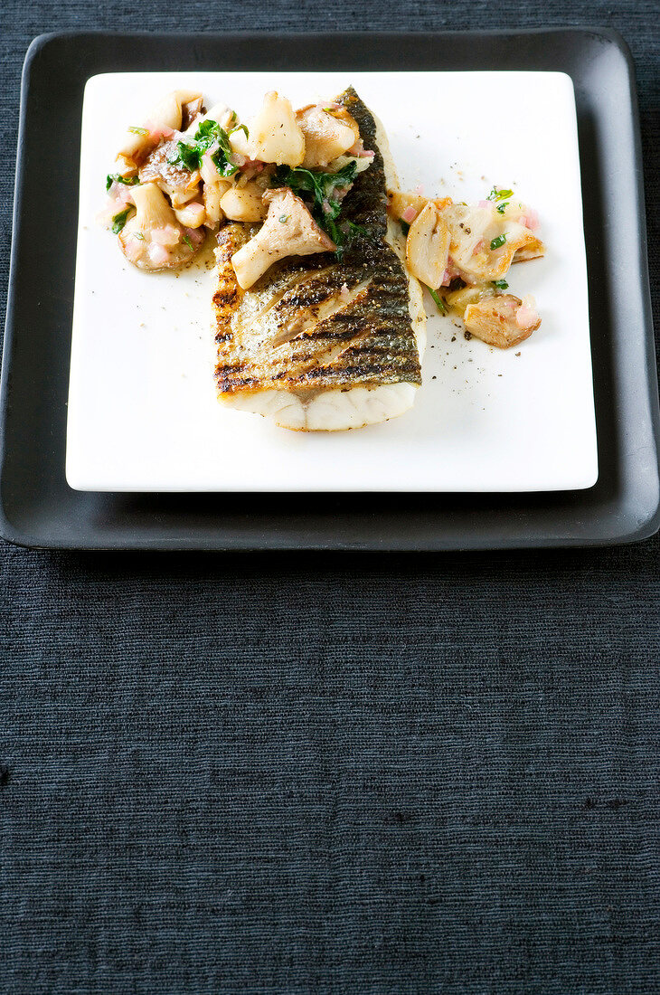 Grilled sea bass fillet with citrus mushrooms, shallots and herbs