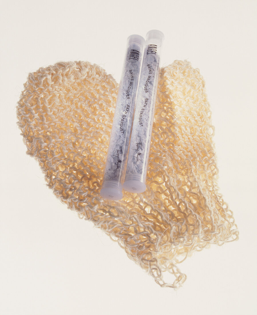 Close-up of two ampoules of bath salt on massage gloves