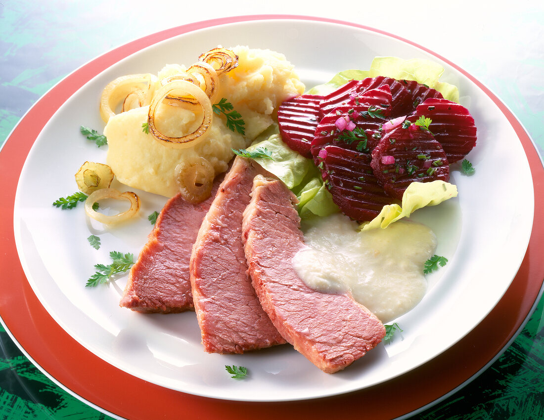 Brisket with beetroot salad, mashed potatoes and horseradish sauce on plate