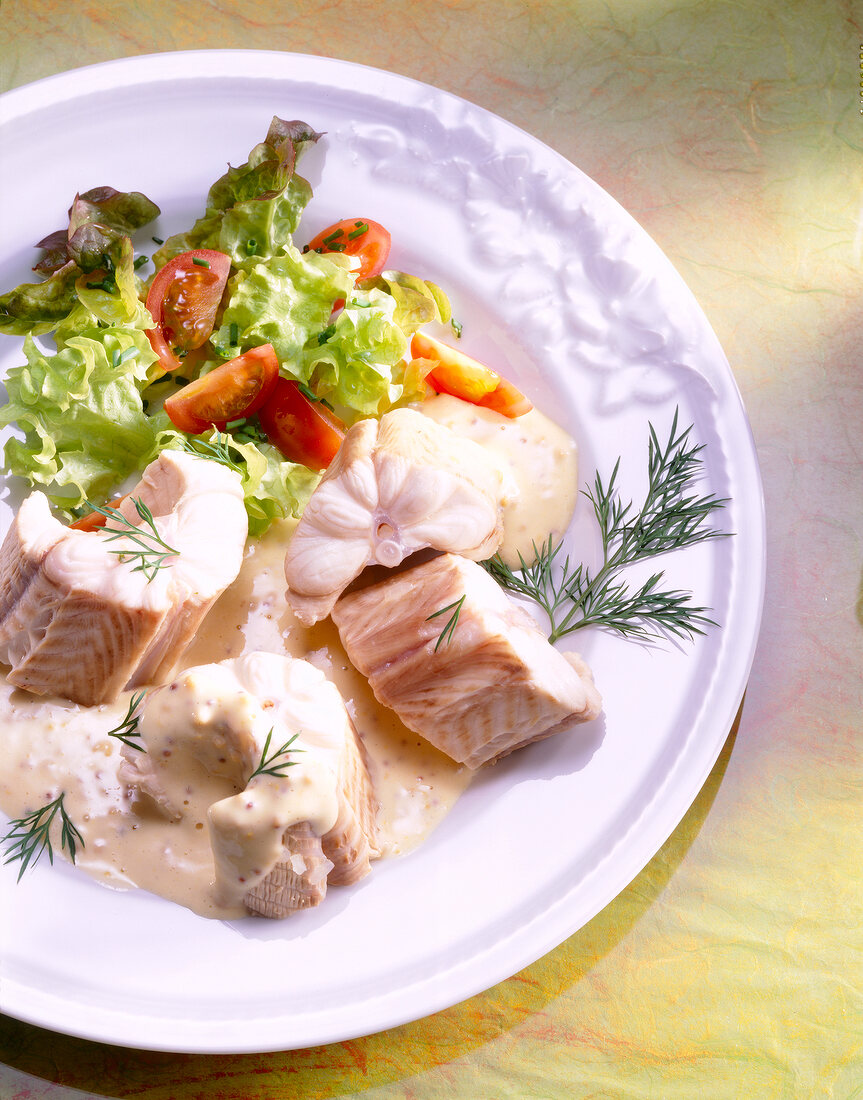 Conger in mustard cream and fresh salad on plate