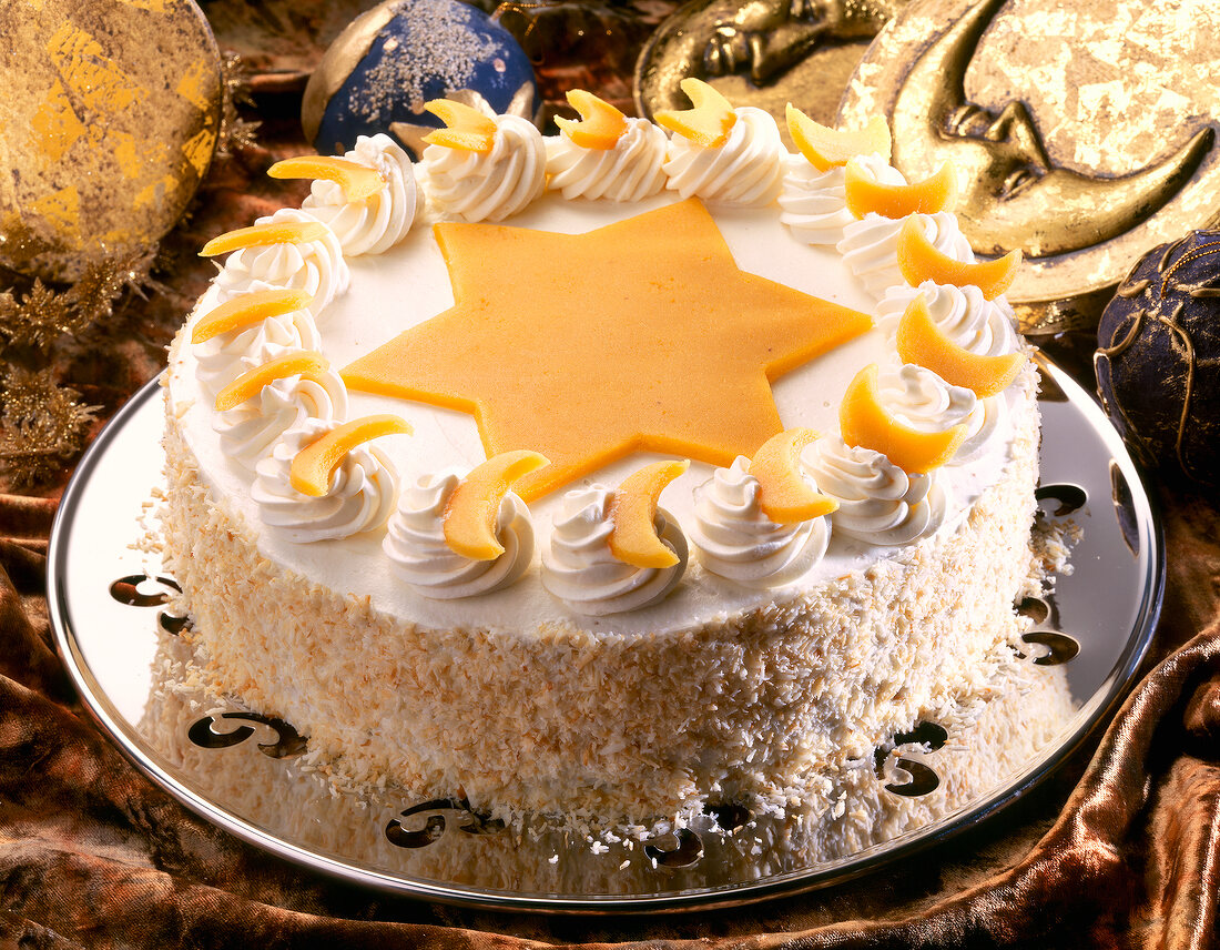 Cream cake with star shaped marzipan and crescents on dish