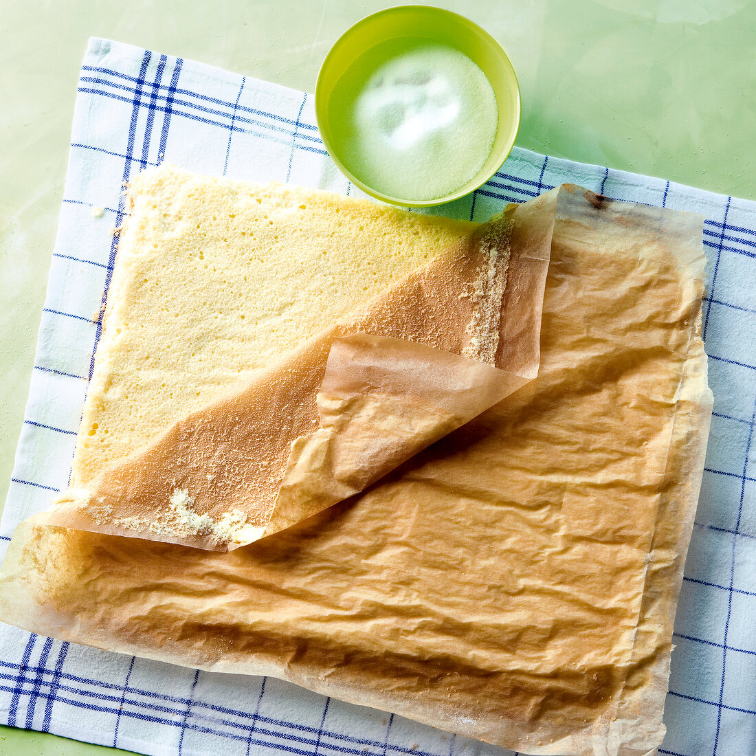 Butter paper being removed from the sponge roll