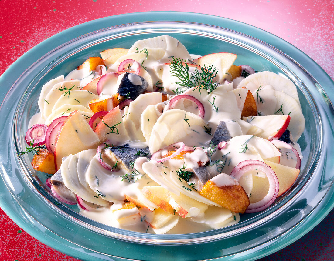 Radish salad with herring fillets and apples in bowl