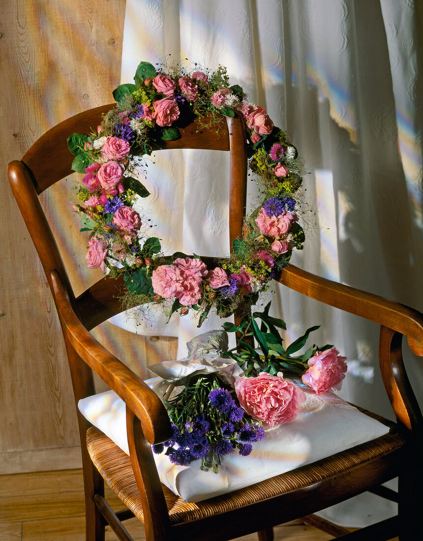 Stillleben: Blumenkranz am Stuhl. 