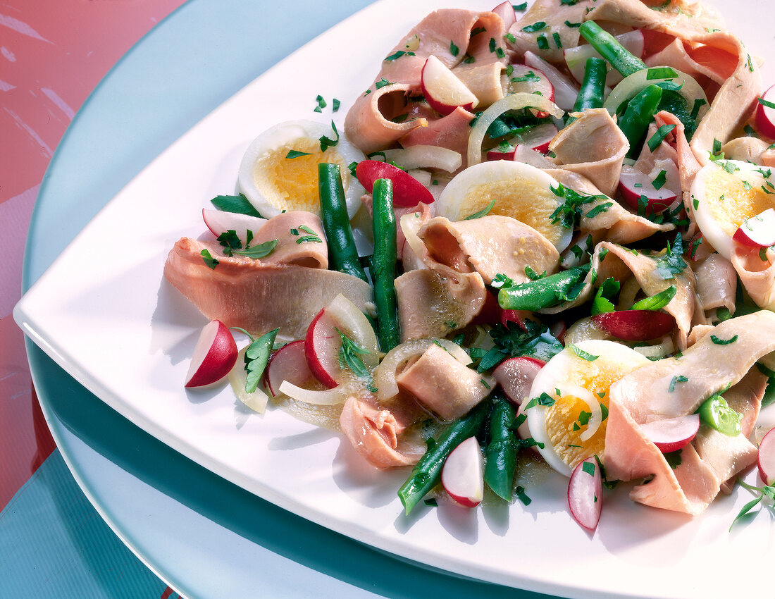 Salad with pork, eggs, beans and herbs on plate