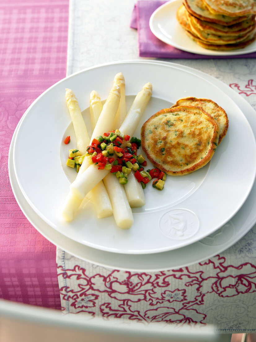 Asparagus with avocado salsa and pancakes on plate