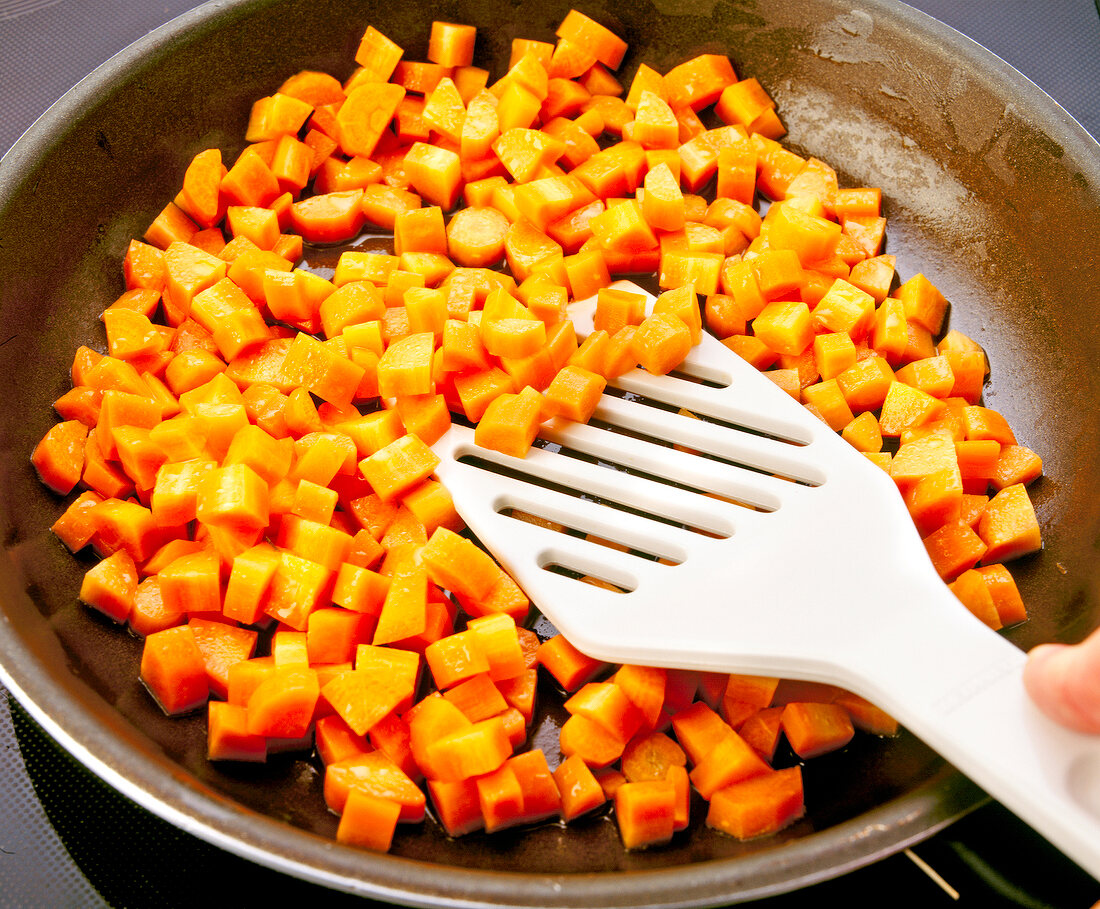 Close-up of diced carrots being saute in the pan