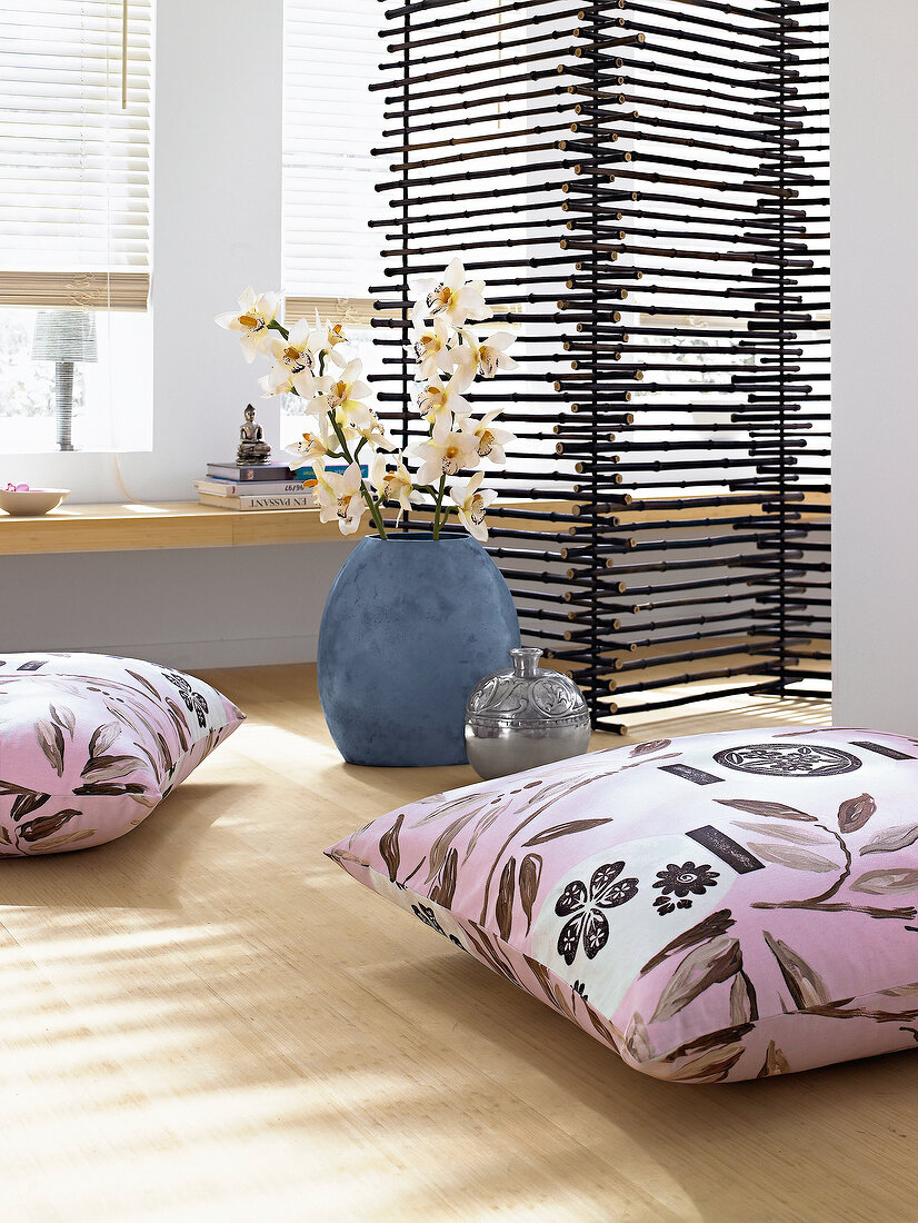 Printed cushions with bamboo leaves, folding screen and white flowers in blue vases