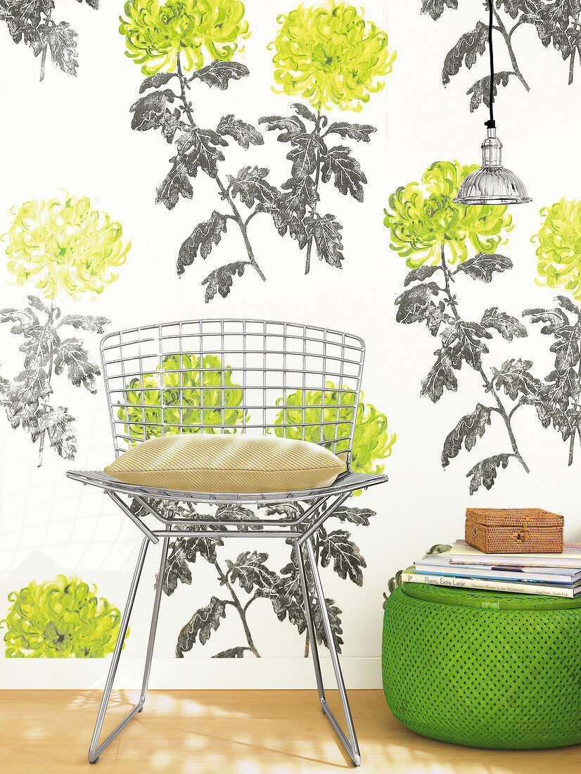 Chair and green bamboo basket in front of floral pattern wallpaper