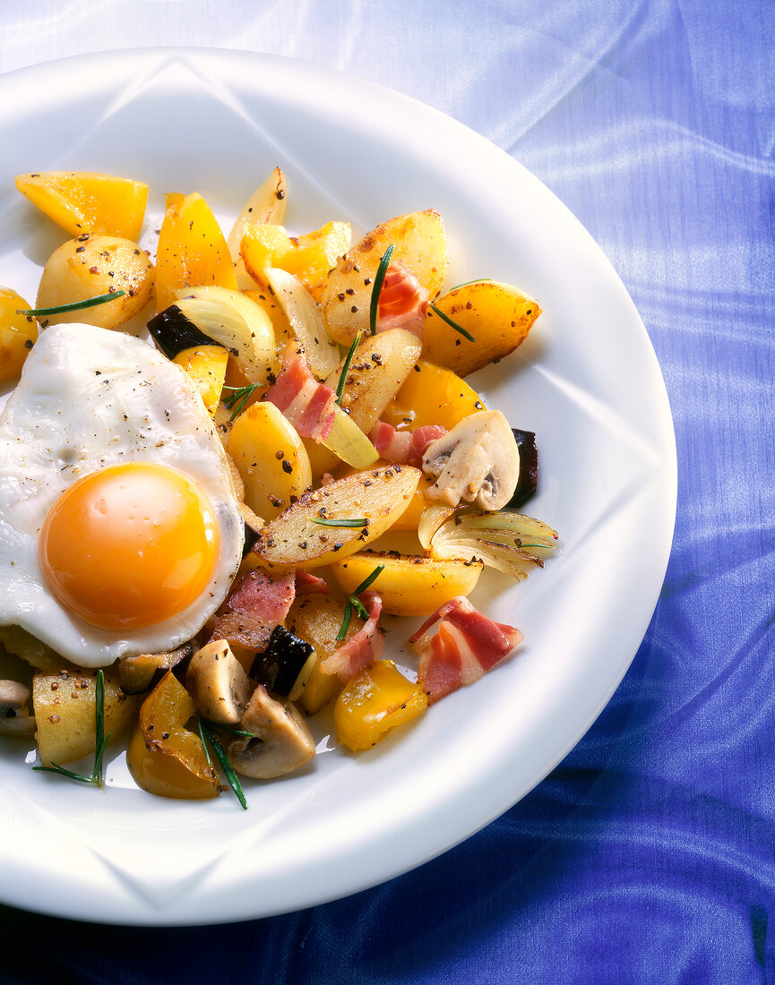 Close-up of stir fried vegetables with a fried egg on top