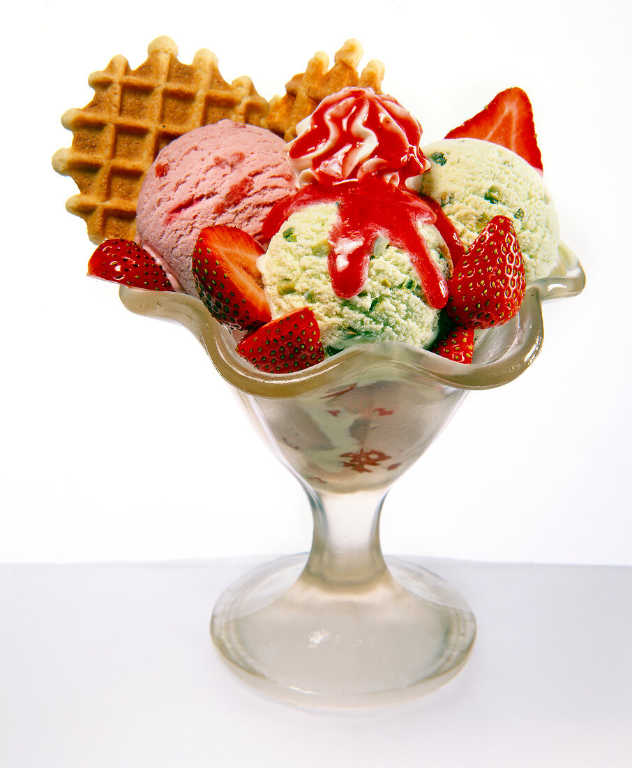 Scoops of ice cream with strawberry and waffle cookies in sundae glass