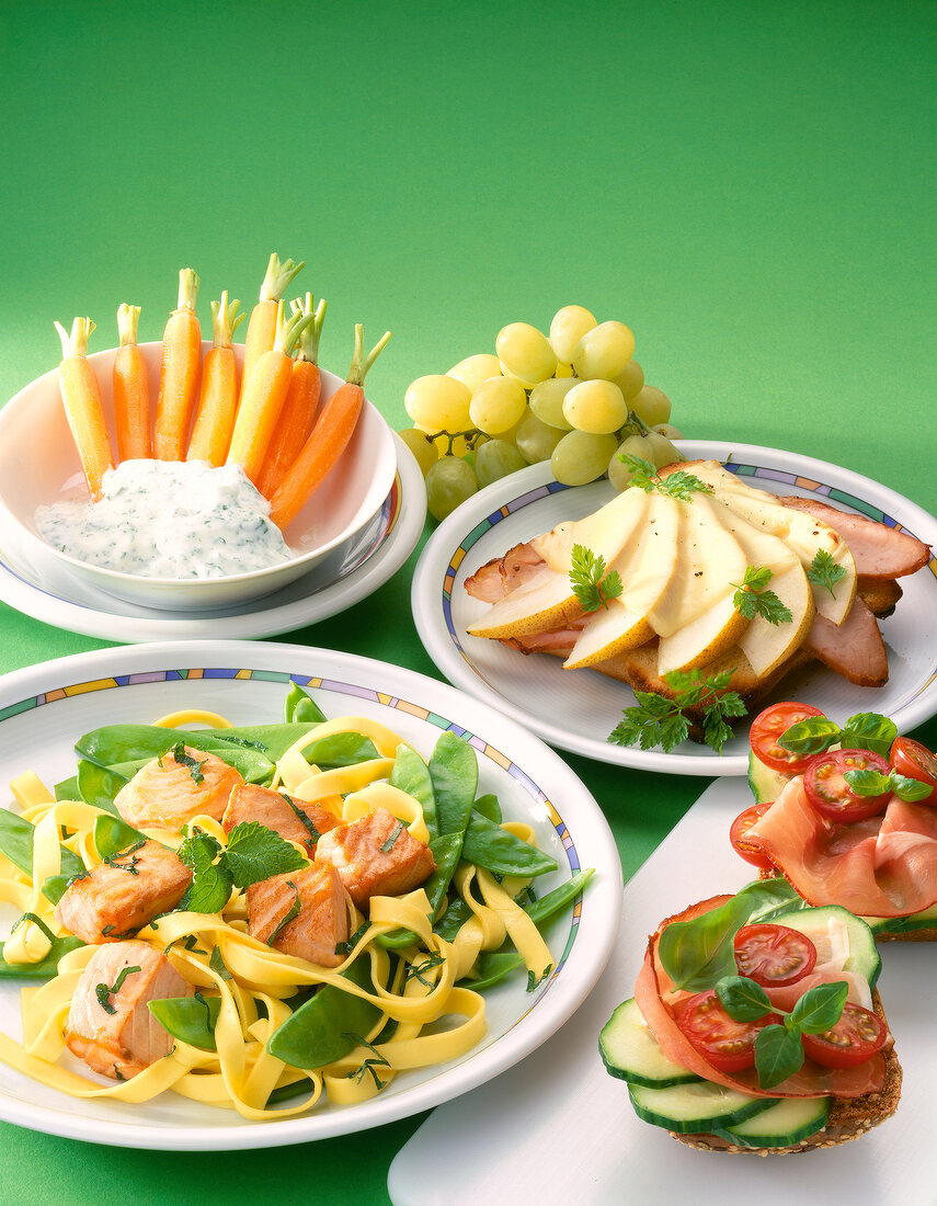Close-up of tagliatelle with salmon, bread with tomato and carrots with dip