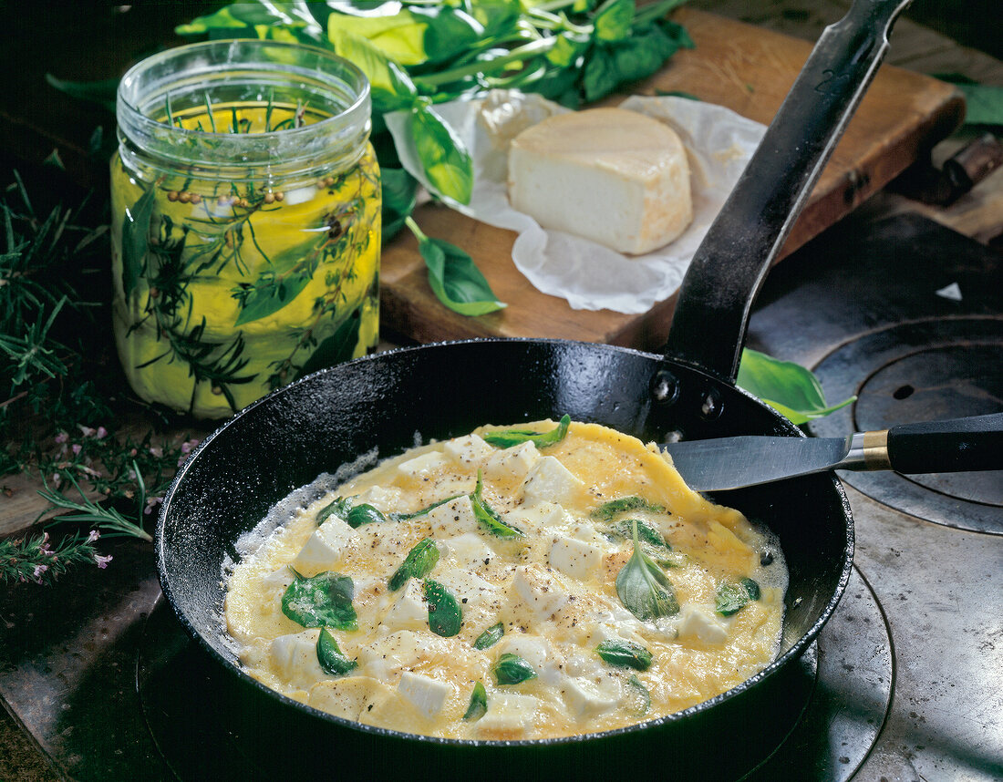 Goat cheese and basil omelette in pan