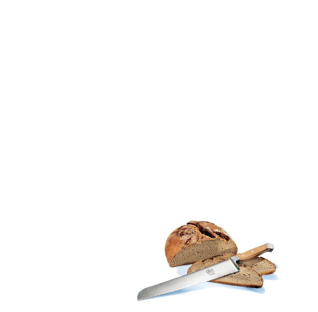 Bread knife with loaf and two slices of bread, copy space