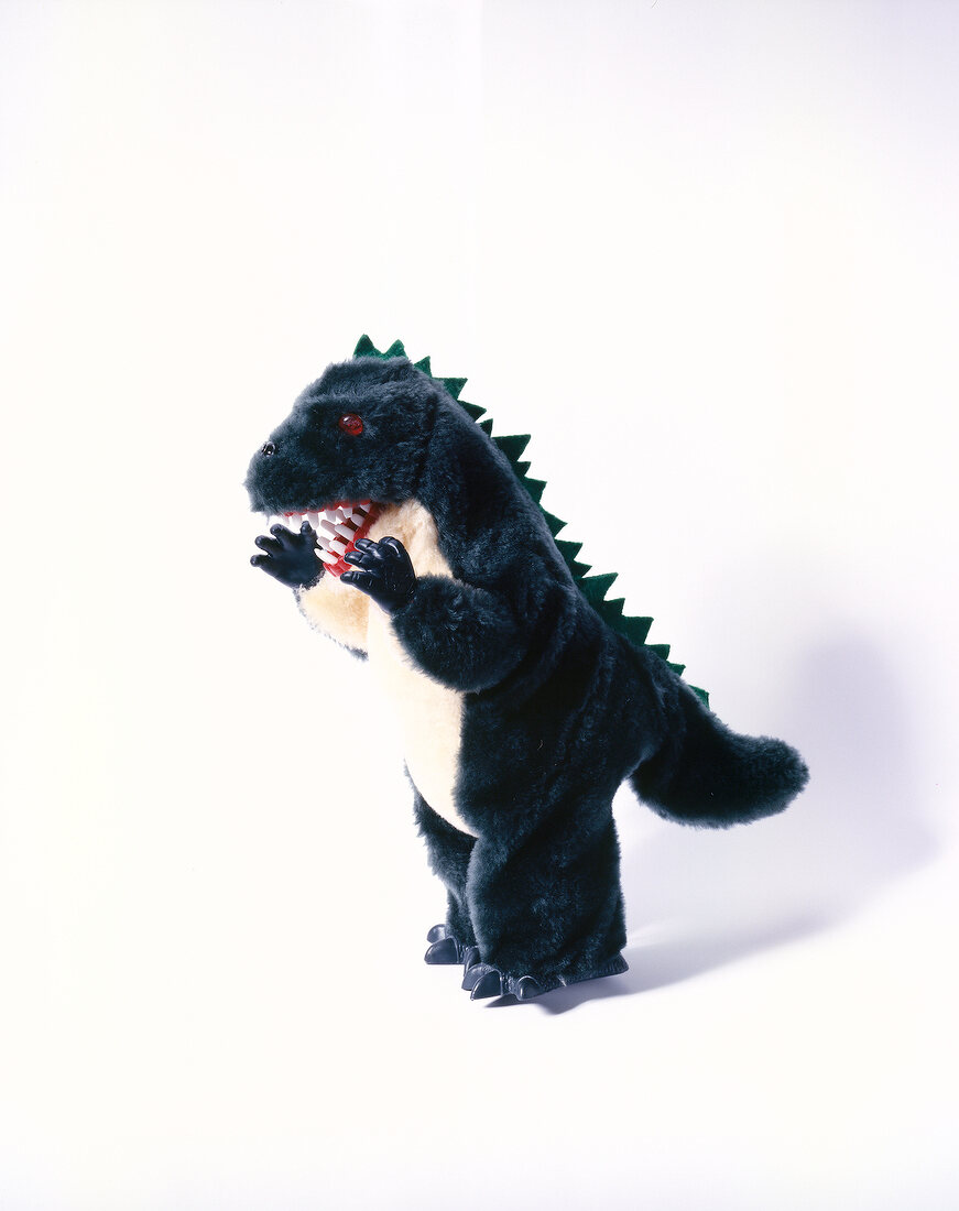 Black plush dinosaur toy on white background