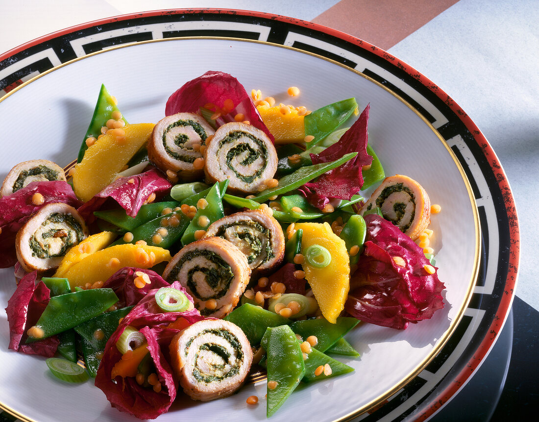 Close-up of chicken salad with mangetout and mango on plate