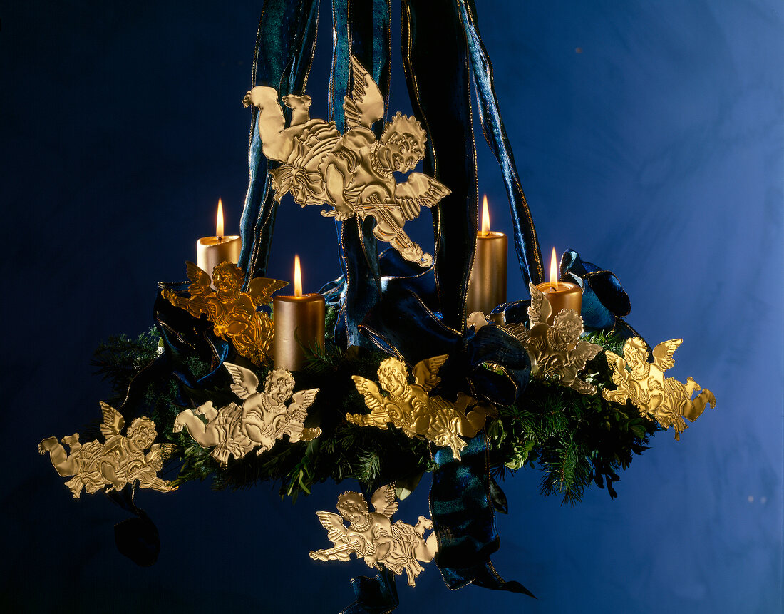 Adventskranz mit blauen Bändern, goldenen Kerzen und Engeln.