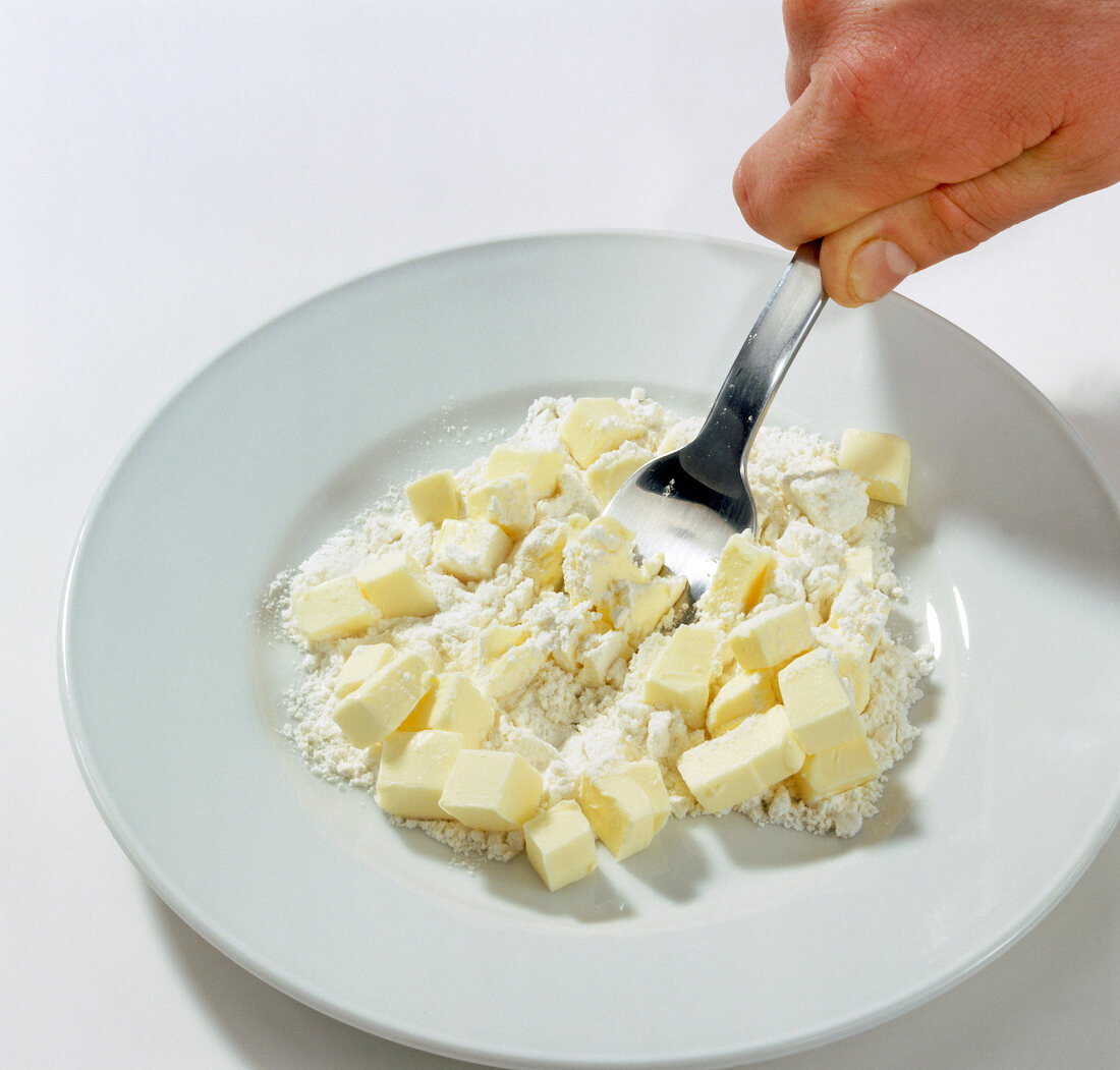 Hand mixing flour and butter on plate, step 1