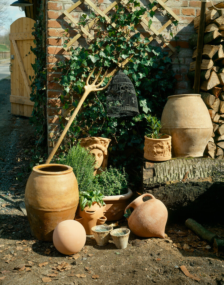 Various clay and terracotta pots in front of house wall