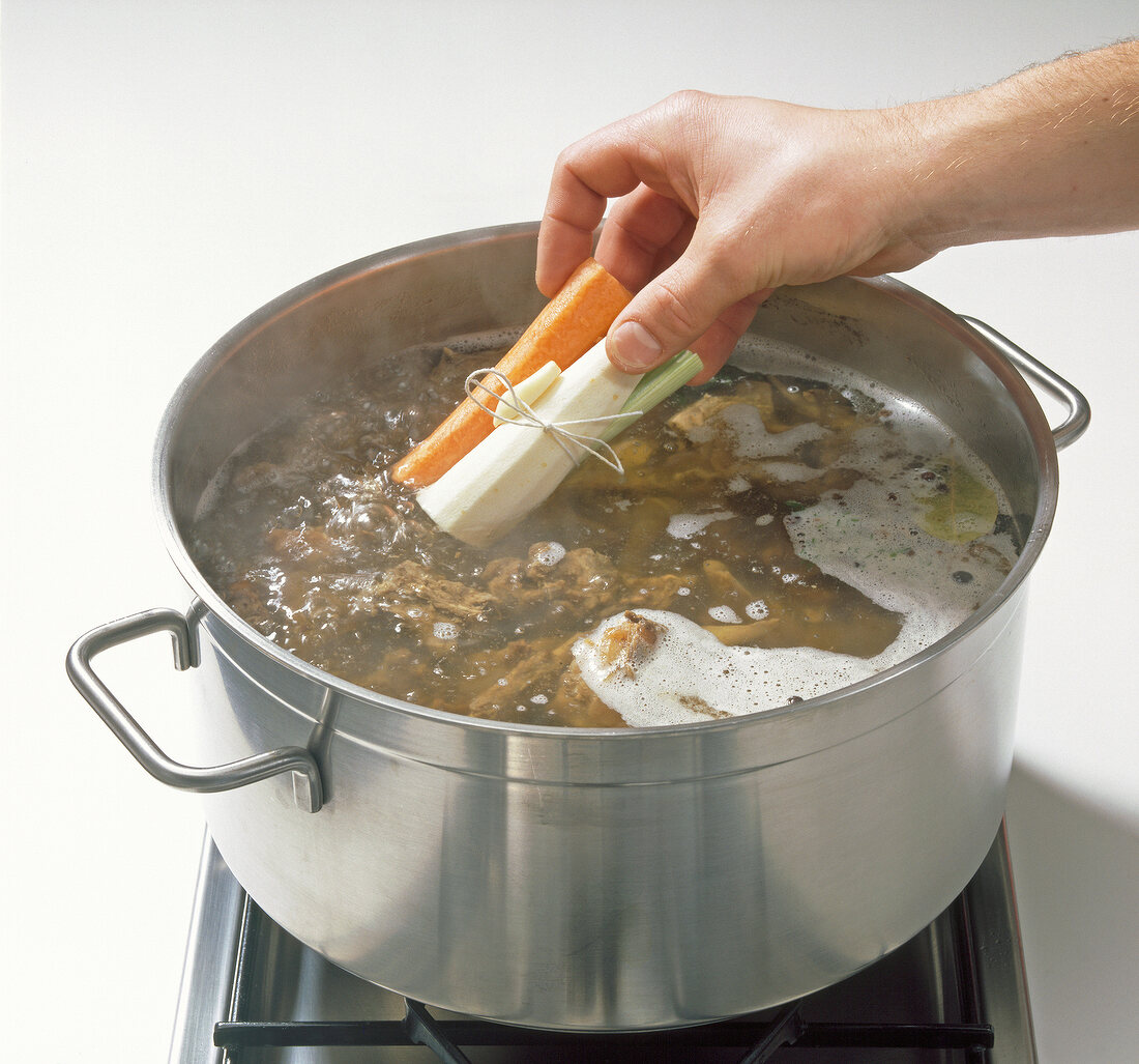 Adding vegetables to mixture in pot, step 6