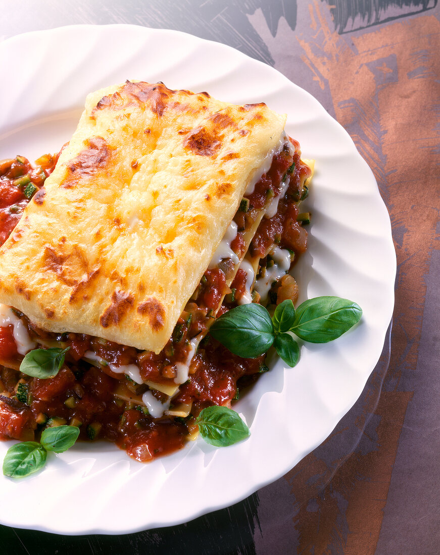 Close-up of lasagne with eggplant, zucchini, mushrooms and onions on plate