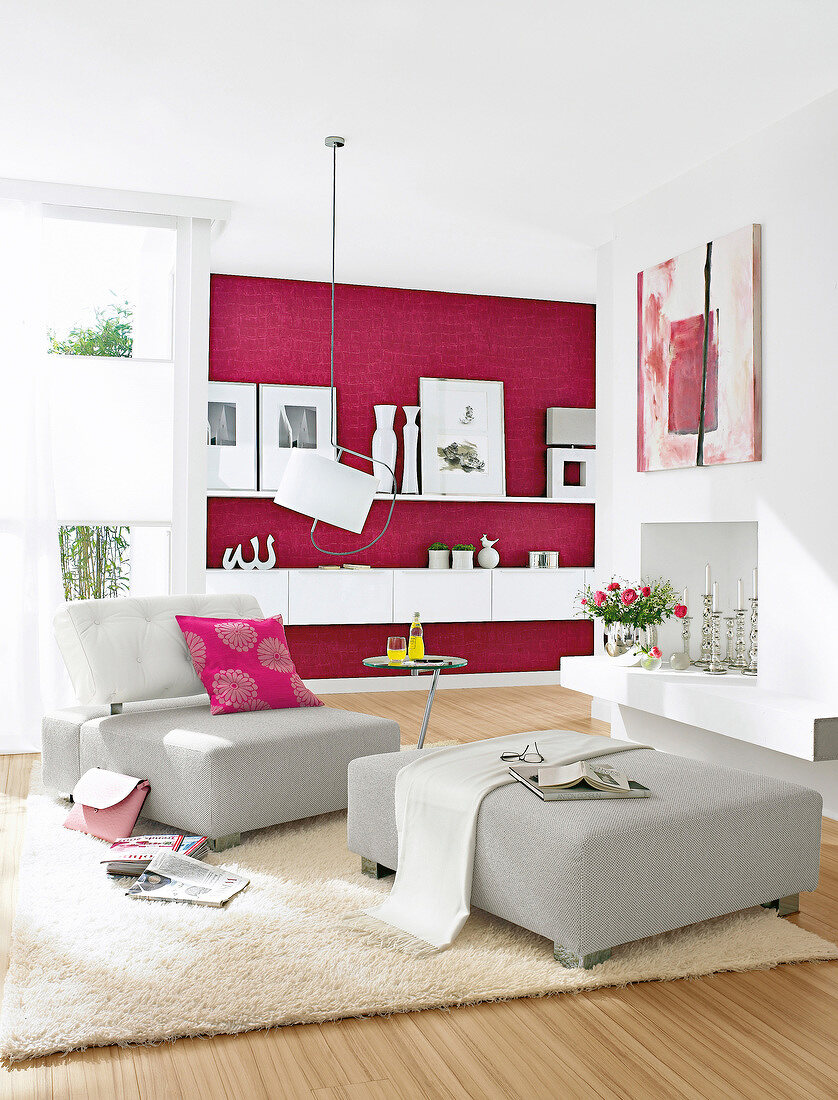 Wohnzimmer in Magenta mit Sessel, Hocker und Hängeboards