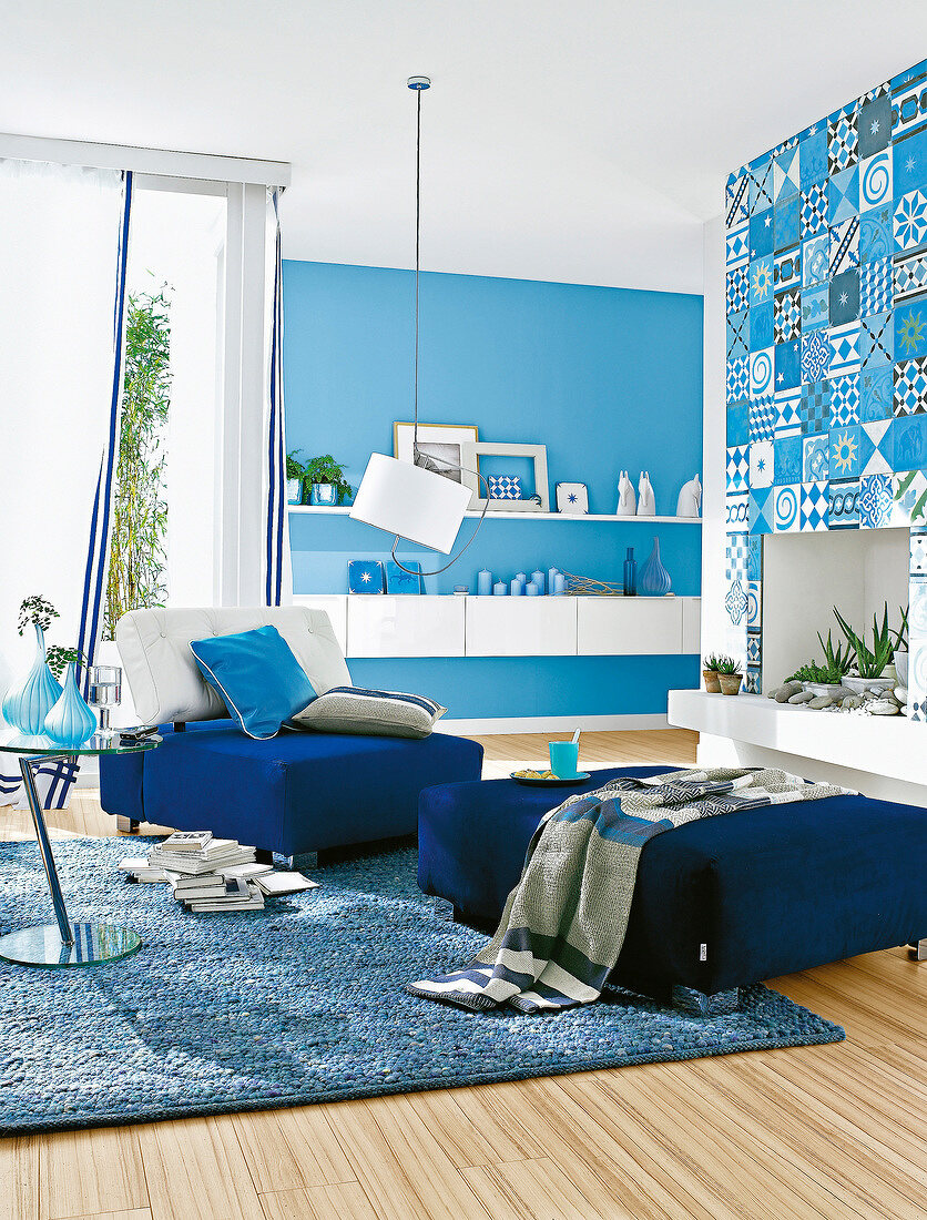 Wohnzimmer in Blau mit Sessel, Hocker und Hängeboards