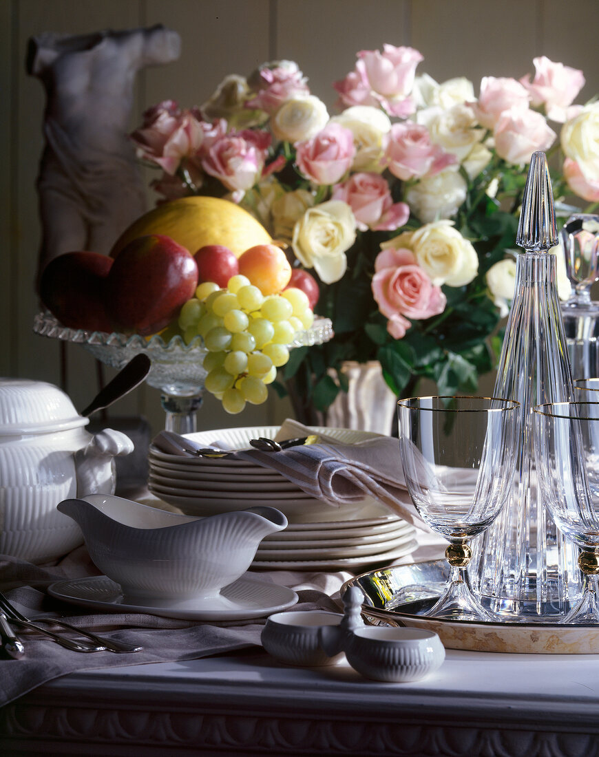 Crockery, fruits and flowers on table