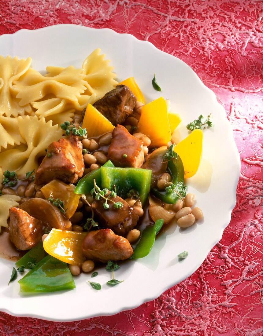 Gulasch mit Bohnen und Paprika, dazu Nudeln, close-up.