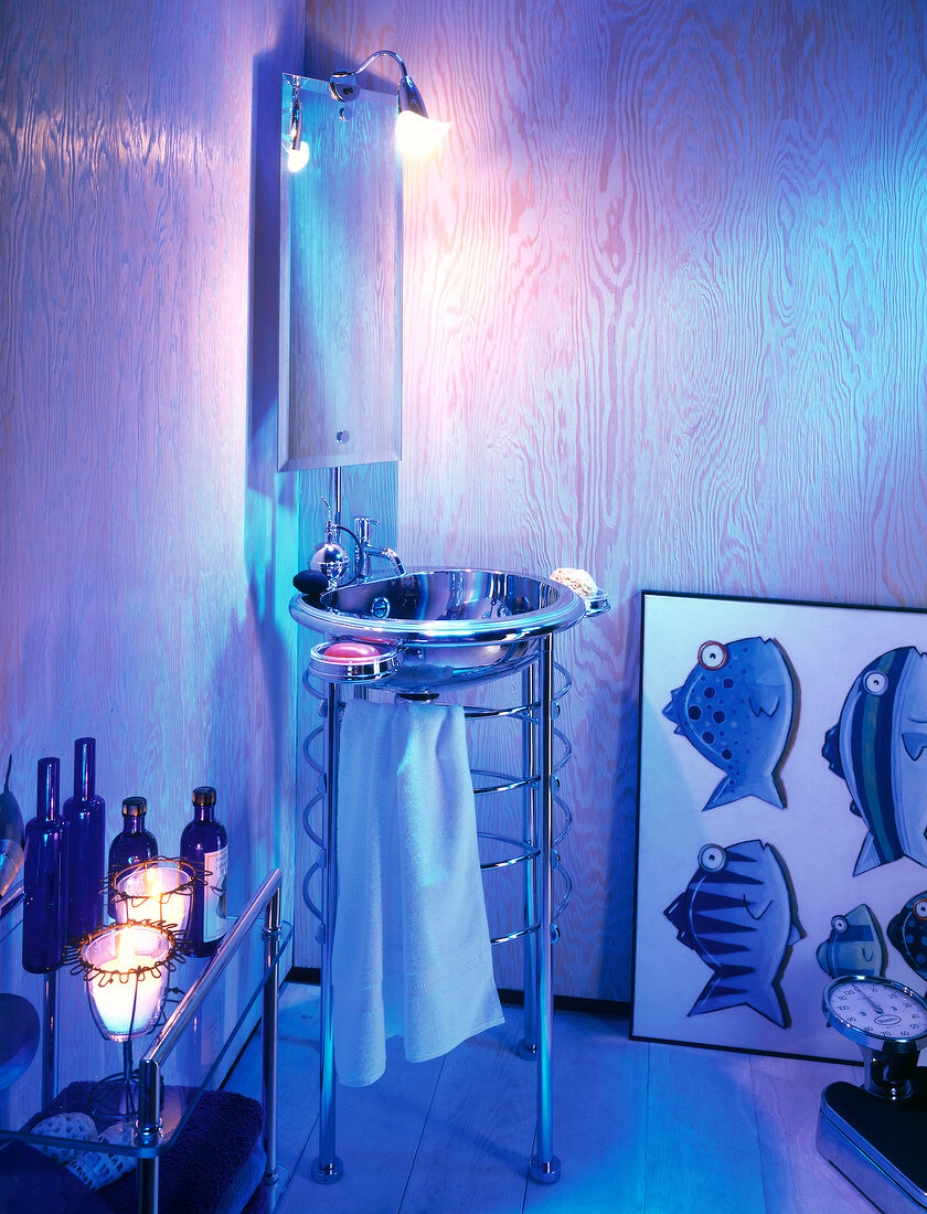 Illuminated wooden bathroom in blue with basin on pedestal