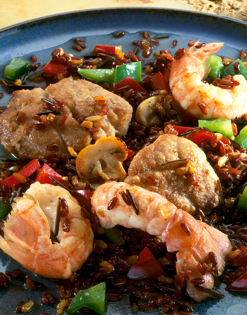 Close-up of risotto with veal, sweetbreads and king prawns on serving dish