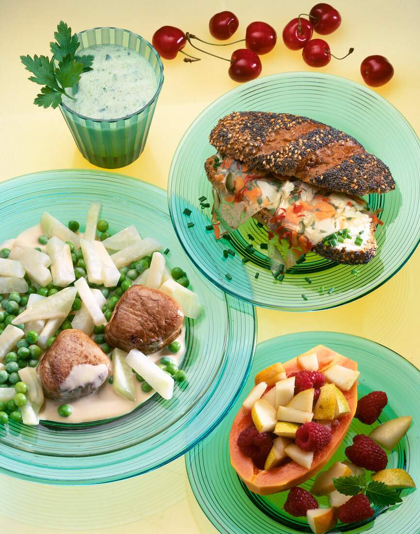 Stuffed papaya, pork with peas, shake with parsley and bread rolls on plate