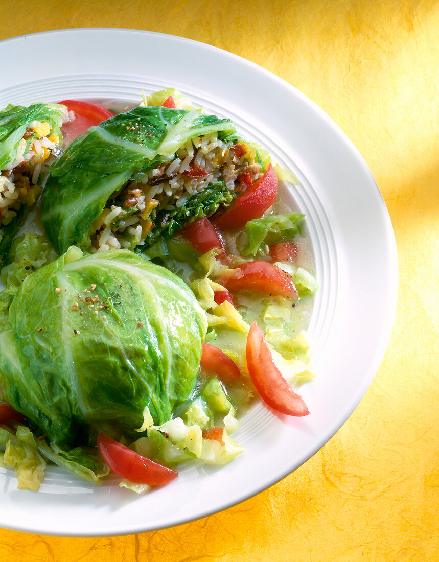 Close-up of savoy cabbage stuffed with meatballs and salad on plate