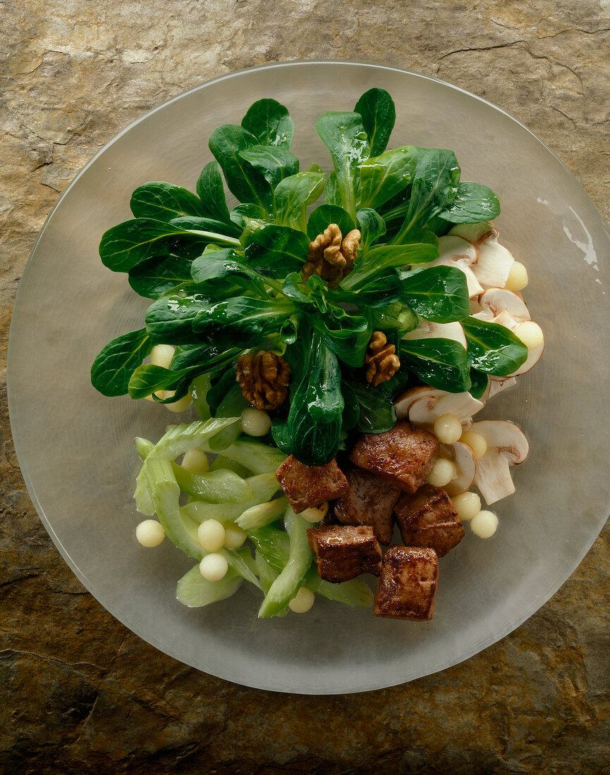 Close-up of corn salad with mushrooms and calf's liver on plate
