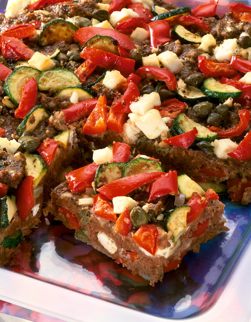 Close- up of Minced meat baked cakes with red peppers, zucchini and feta cheese