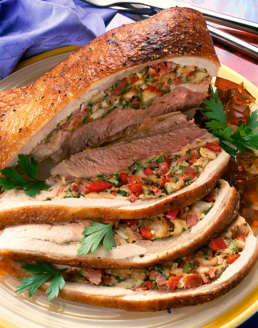 Close-up of filled veal breast with peppers, diced ham and parsley
